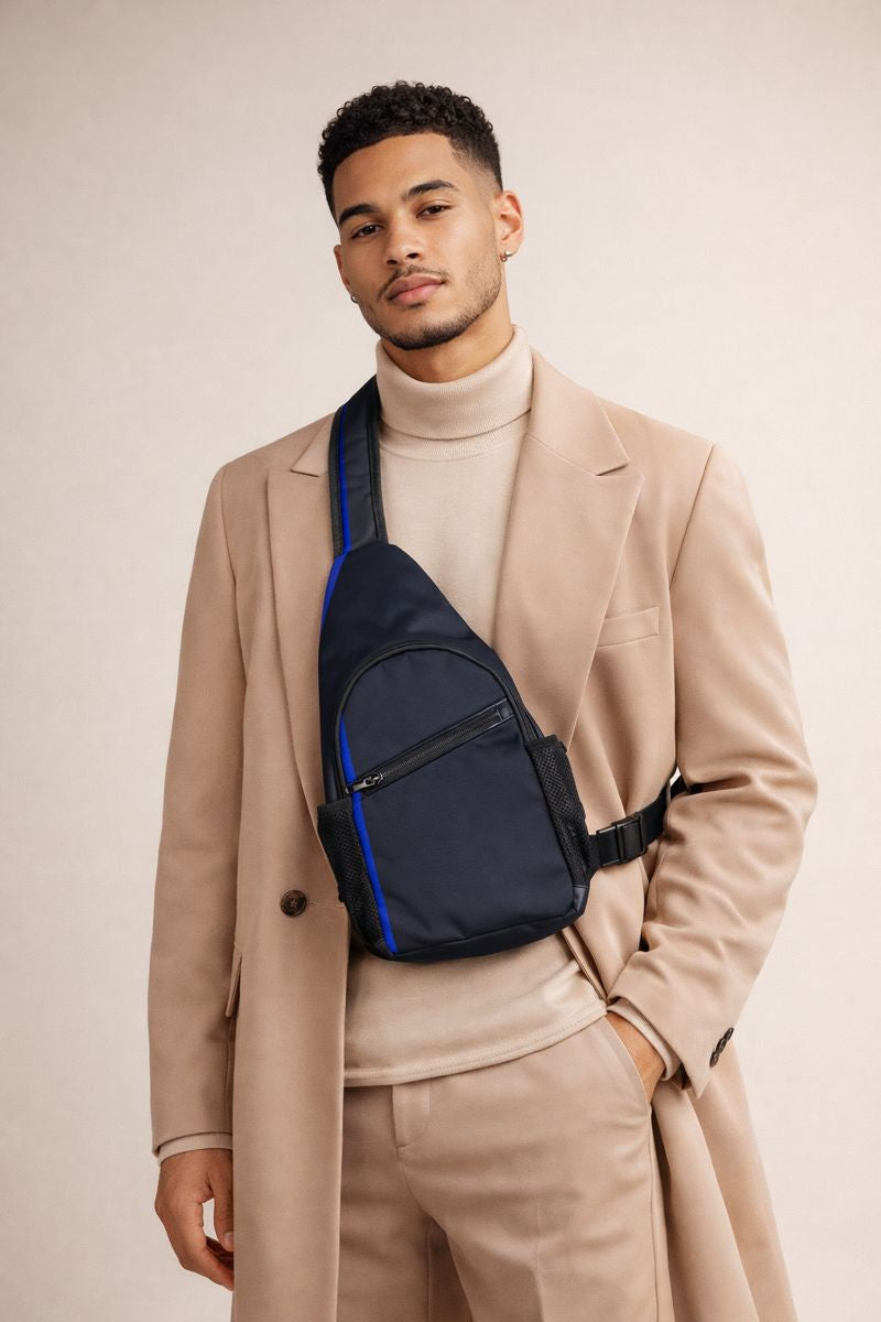 A person in a tan suit wearing a dark crossbody sling bag.