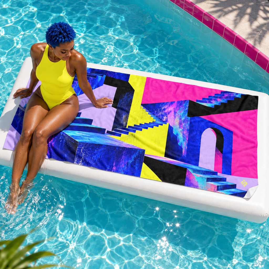 Woman seated beside Level Unlocked beach towel at a pool.