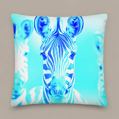 Large square Blurred Lines pillow with a central blue zebra and pale cyan background. On a warm greige studio background.