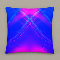 Large square Liquid Mirage pillow with electric blue and magenta mirrored light forms. On a warm greige studio background.