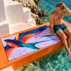 Man beside Beyond the Current beach towel on poolside steps.