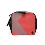 Left-side view of a burgundy, black, and coral geometric duffle bag with a light gray panel.