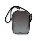 Plain gray back of the Unruly crossbody bag with its black strap.