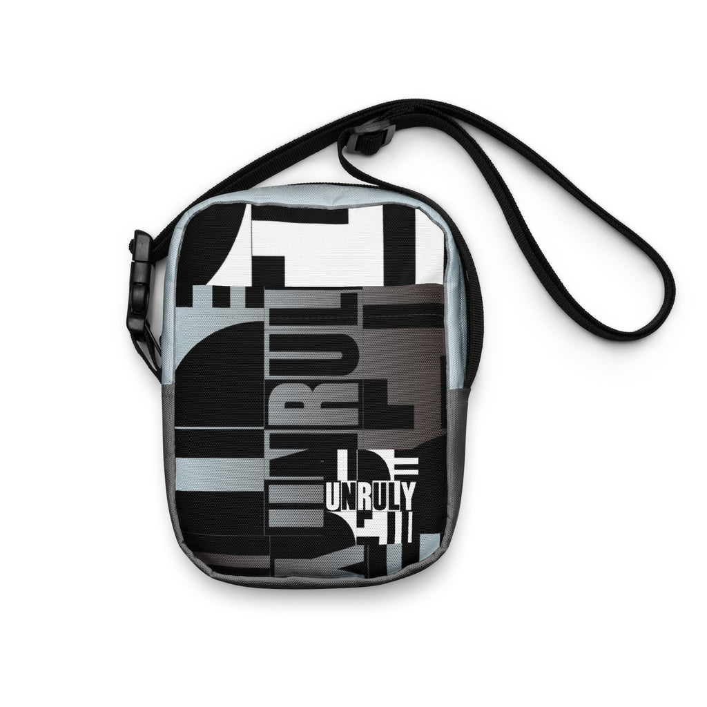 Front view of the Unruly crossbody bag with black, white, and gray geometric typography.