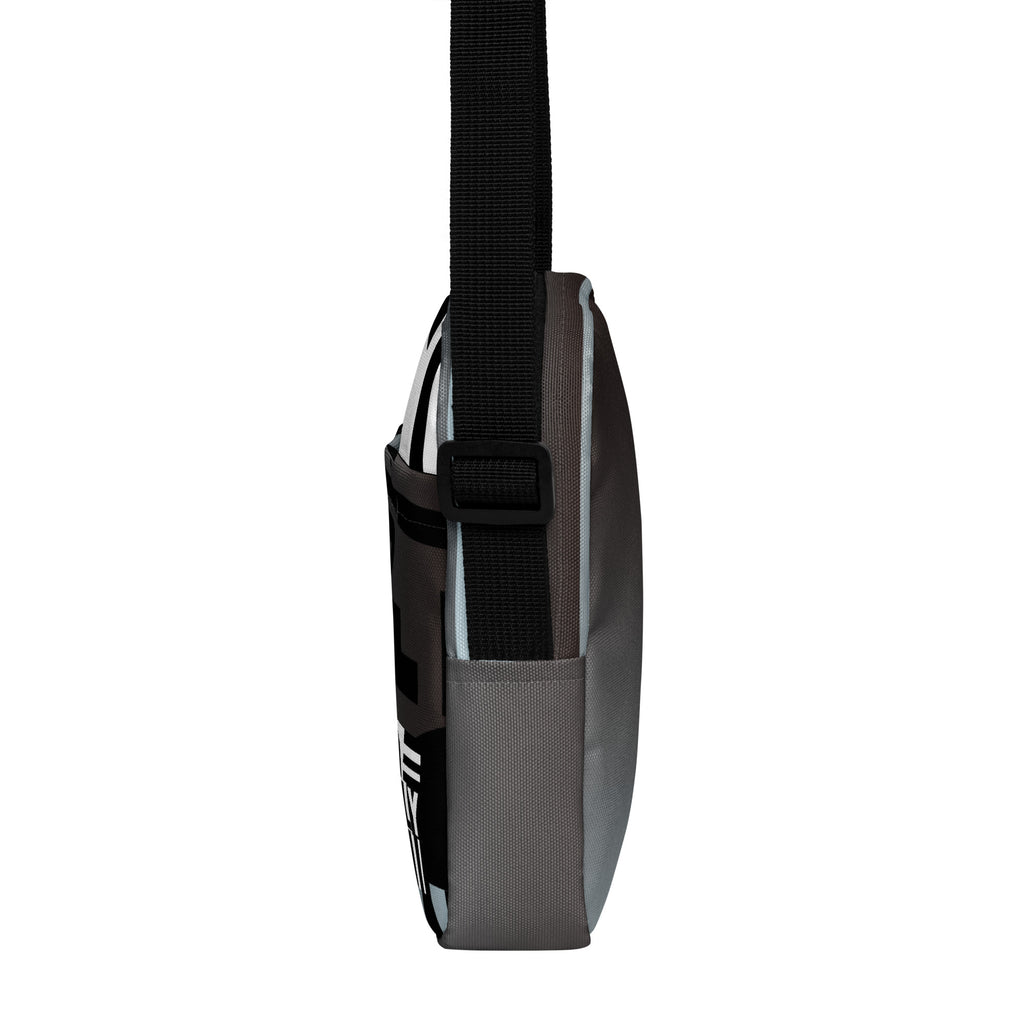 Narrow side view of the Unruly crossbody bag with its black adjustable strap.