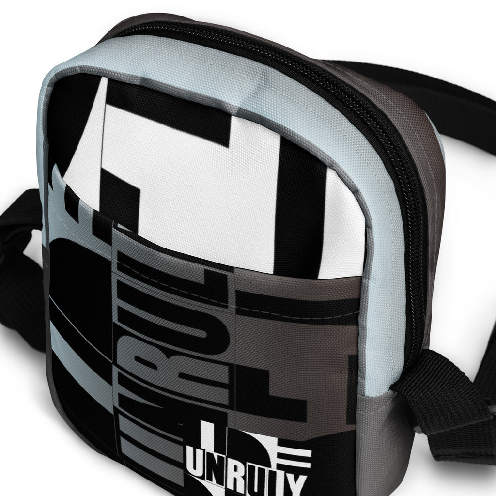 Close-up of the Unruly bag's front pocket, geometric typography, and black top zipper.