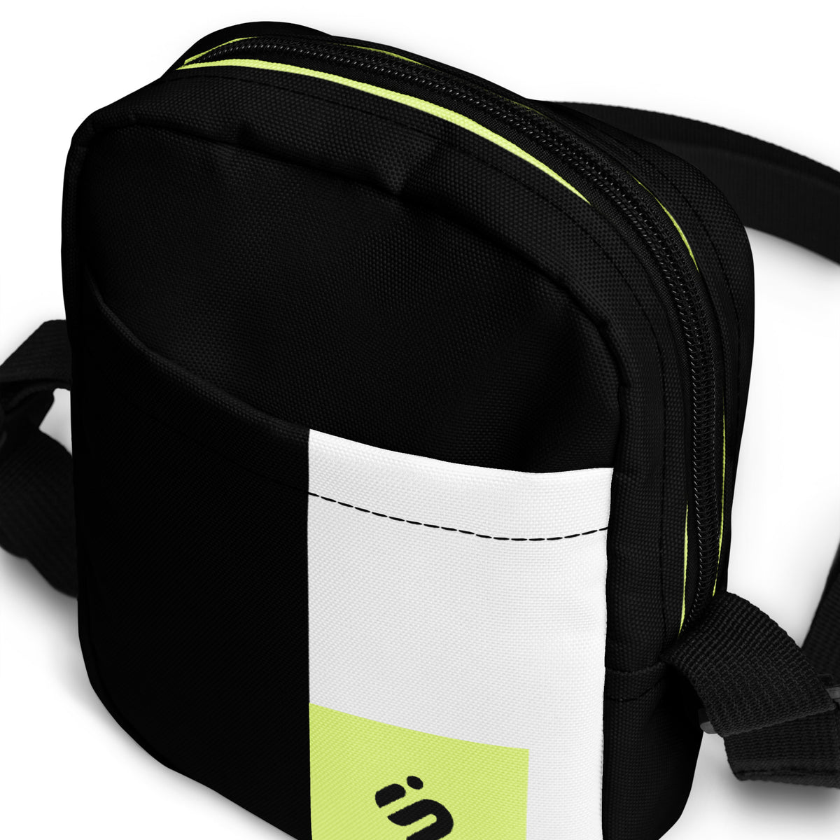Close-up of the Personal Baggage bag's black front pocket, white stripe, and yellow-green zipper accent.