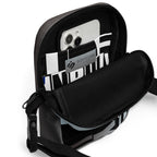 Open Unruly crossbody bag showing a phone in its black-and-white patterned interior pocket.