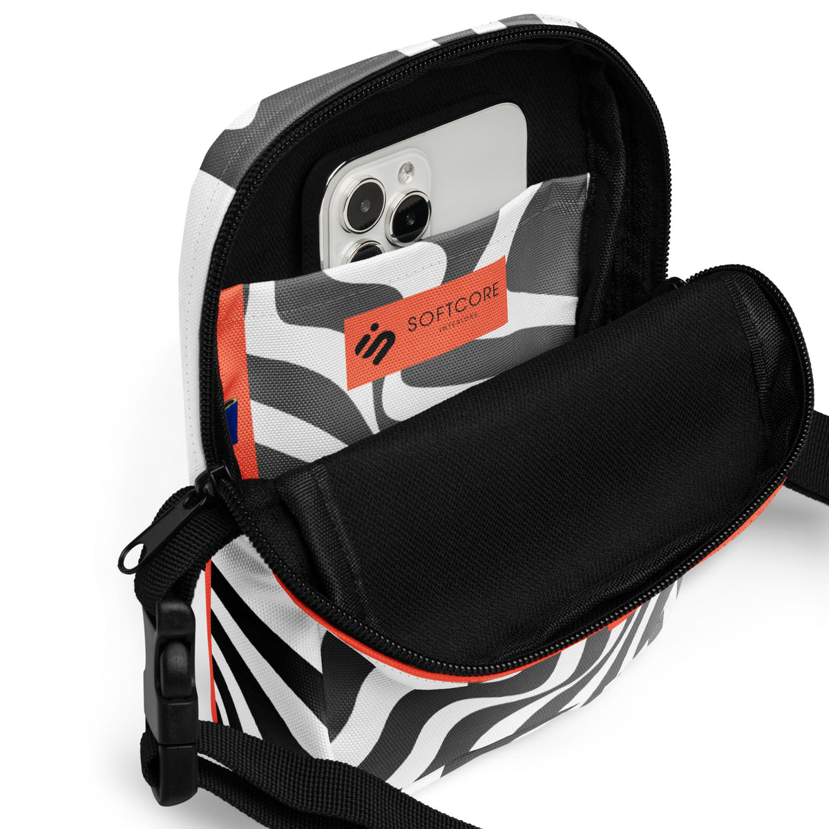 Open Wrong Turn crossbody bag showing a phone in its black-and-white patterned interior pocket.