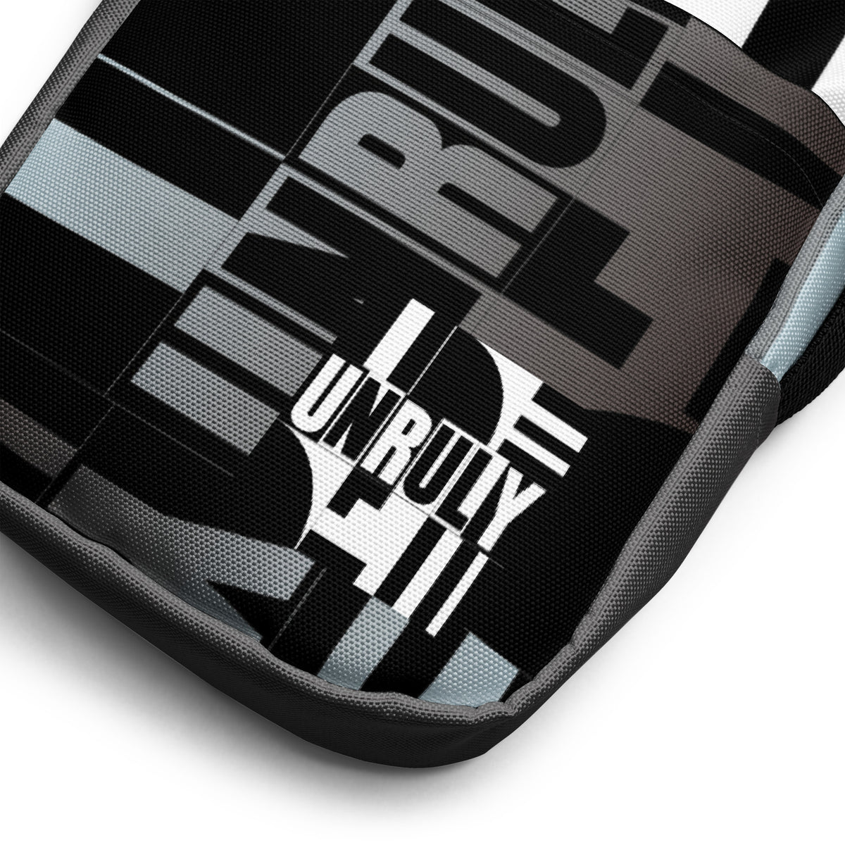 Close-up of the Unruly bag's black, white, and gray design with bold “UNRULY” lettering.