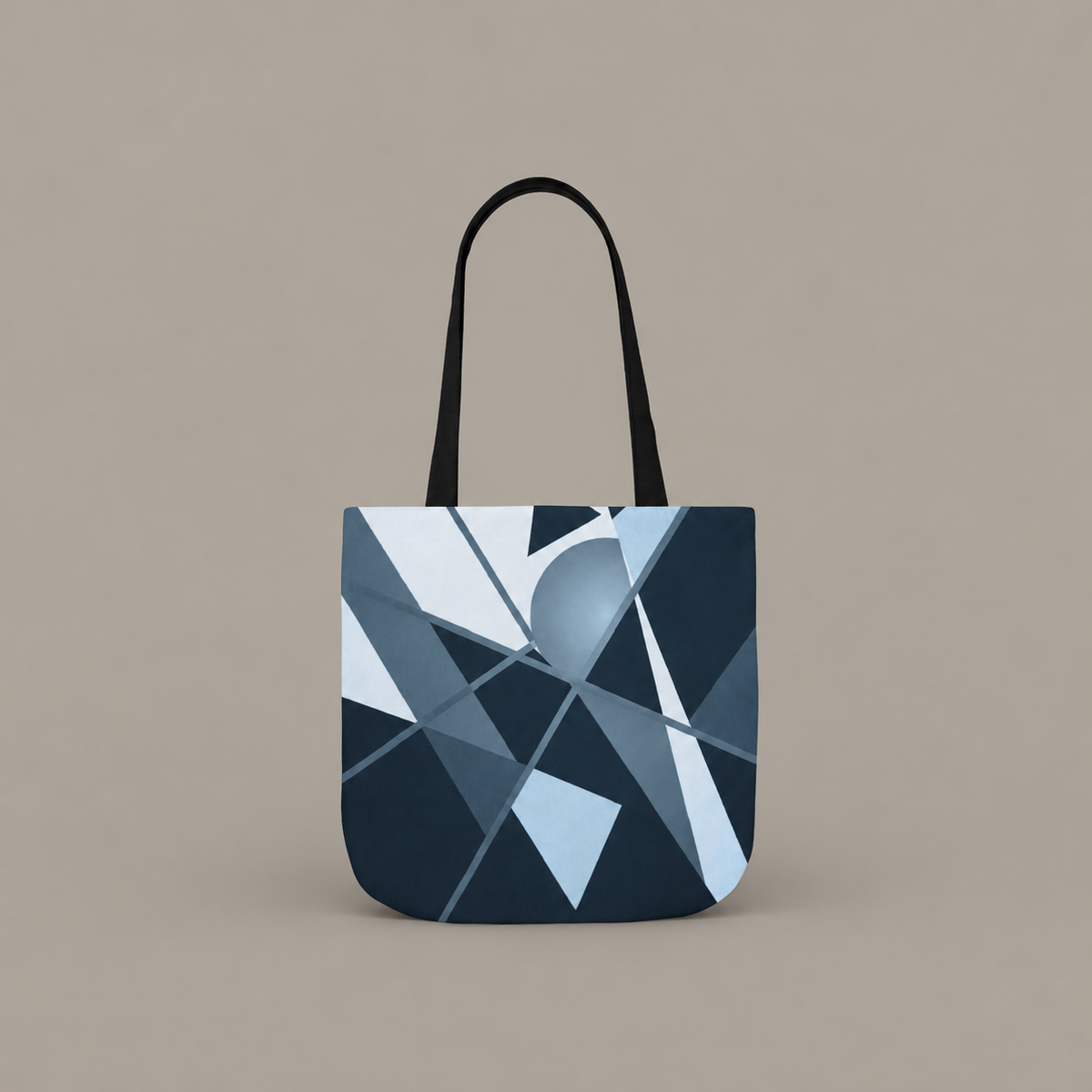 Angles in Transit shoulder tote bag with geometric navy and blue artwork on a warm greige studio background.
