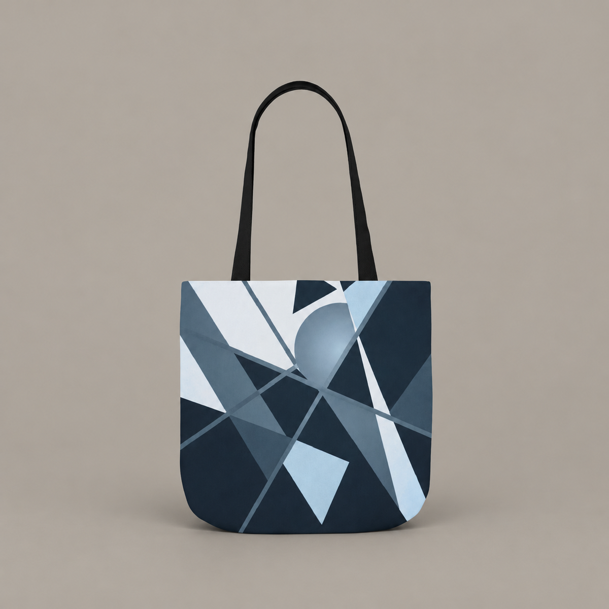 Angles in Transit shoulder tote bag with geometric navy and blue artwork on a warm greige studio background.