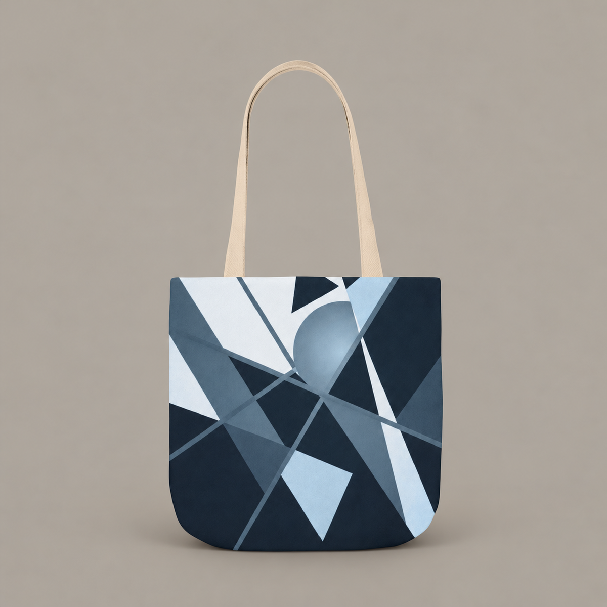 Angles in Transit shoulder tote bag with geometric navy and blue artwork on a warm greige studio background.