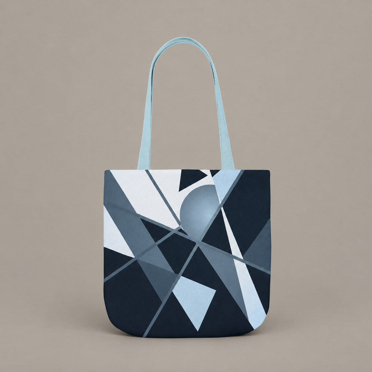 Angles in Transit shoulder tote bag with geometric navy and blue artwork on a warm greige studio background.