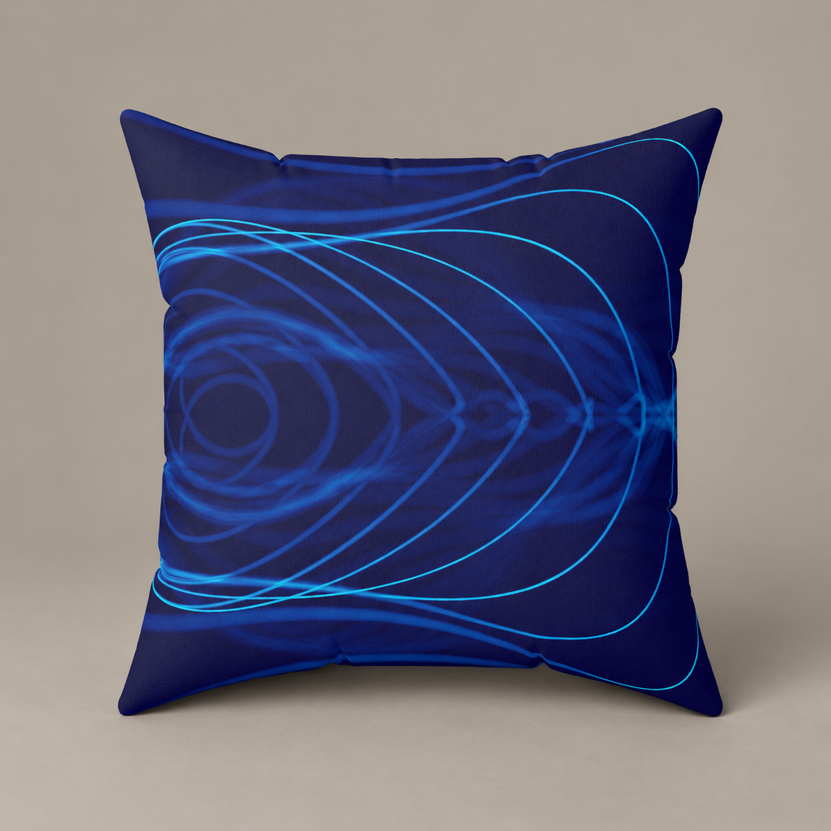 Electric Field Trip faux-suede pillow with cyan curved lines across deep blue on a warm greige studio surface.