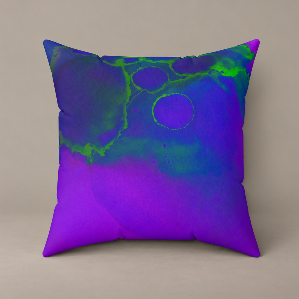 Toxic Glow-Up faux-suede pillow with blue, violet and vivid green abstract artwork on a warm greige studio surface.