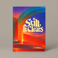 Still, It Clears hardcover journal front cover on a warm greige studio background with a soft shadow